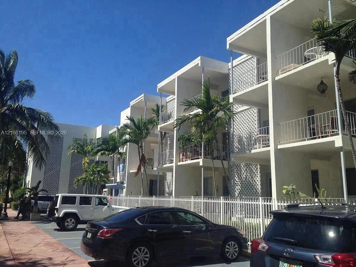 Multi-story exterior featuring concrete structural framing, decorative lattice screen walls, and private tiered balconies with metal railings