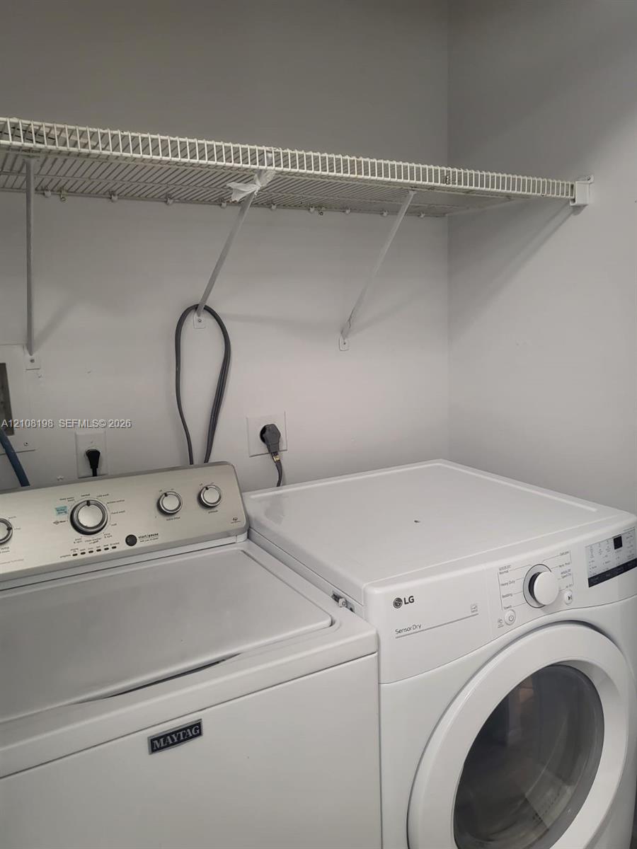 Laundry area featuring a wire-grid wall-mounted shelving unit