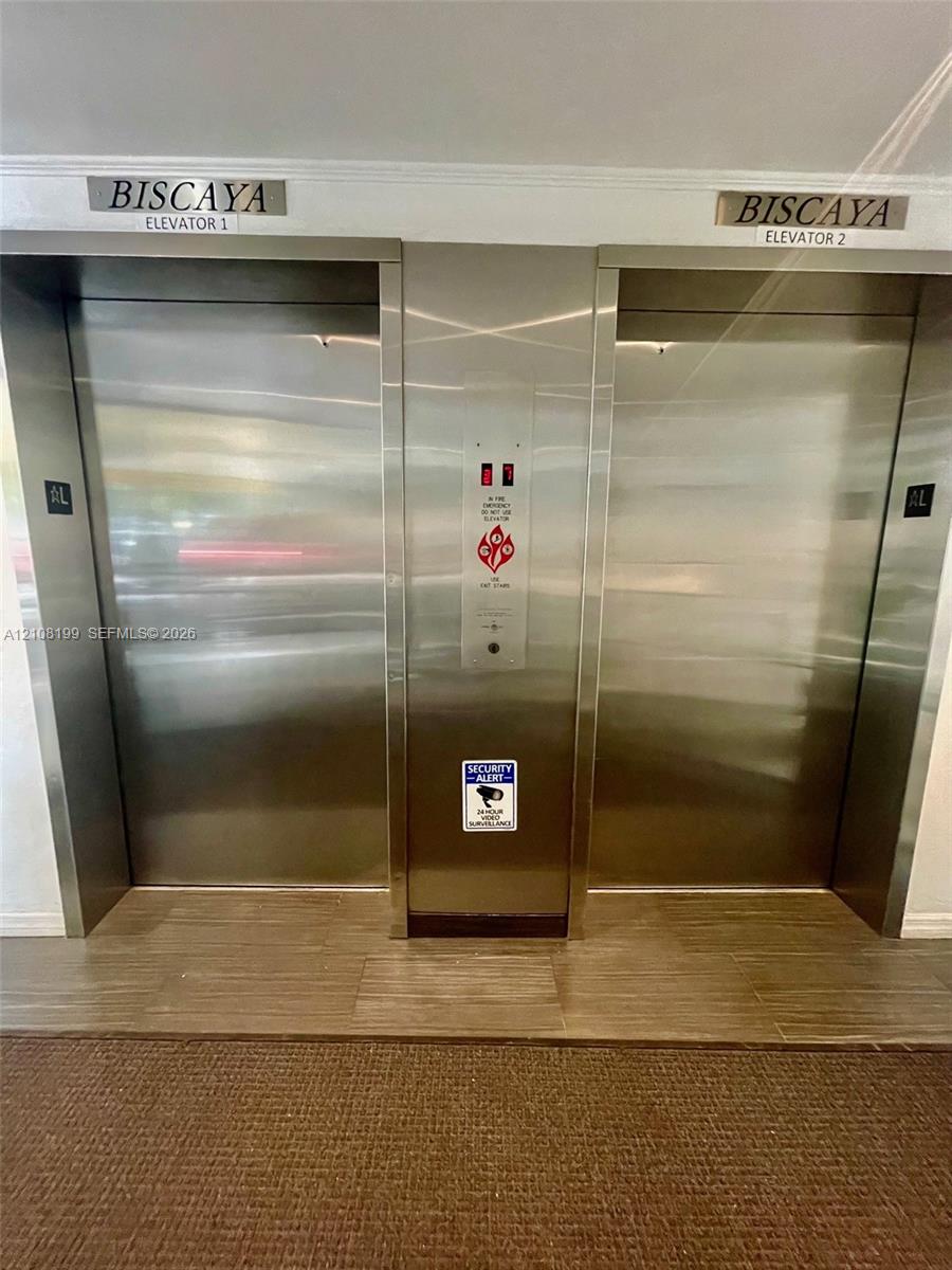 Dual stainless steel elevator banks featuring polished metal finishes and integrated call panels Dual stainless steel elevator banks featuring polished metal finishes and integrated call panels