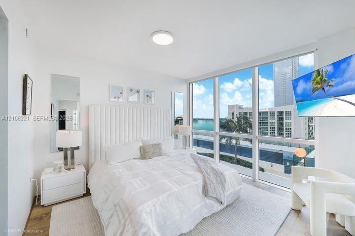Floor-to-ceiling windows, wood-finish flooring, and recessed ceiling lighting