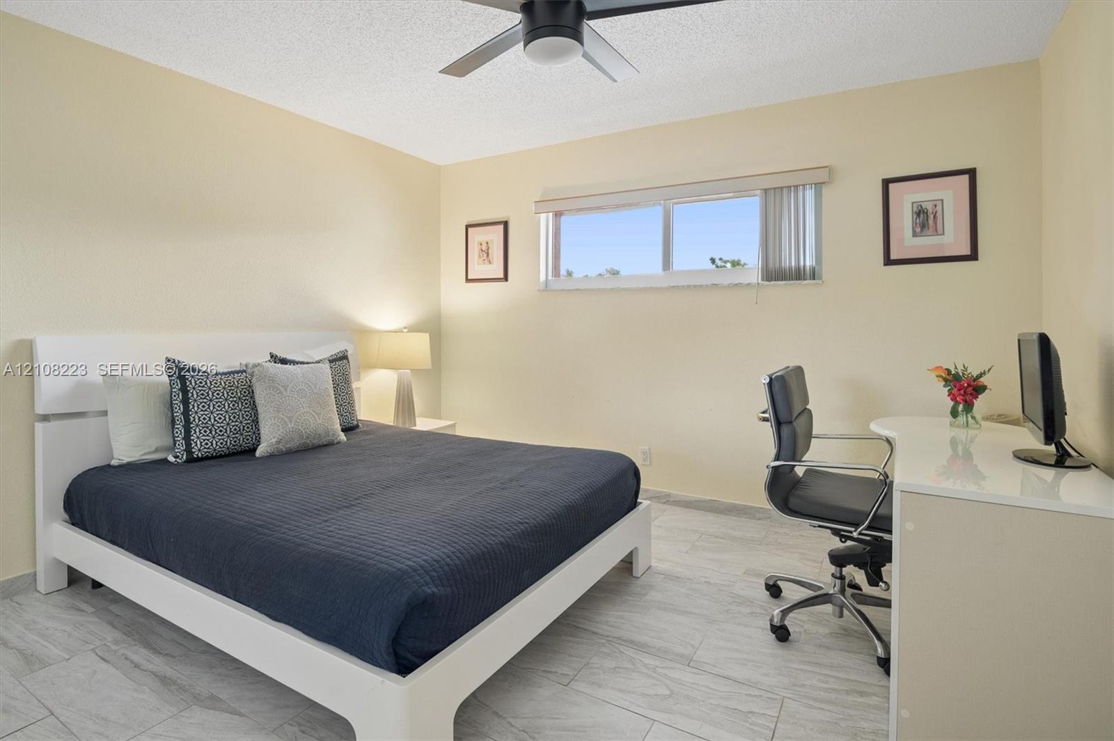 Room featuring neutral wall paint, tile flooring, and a ceiling-mounted fan with integrated lighting