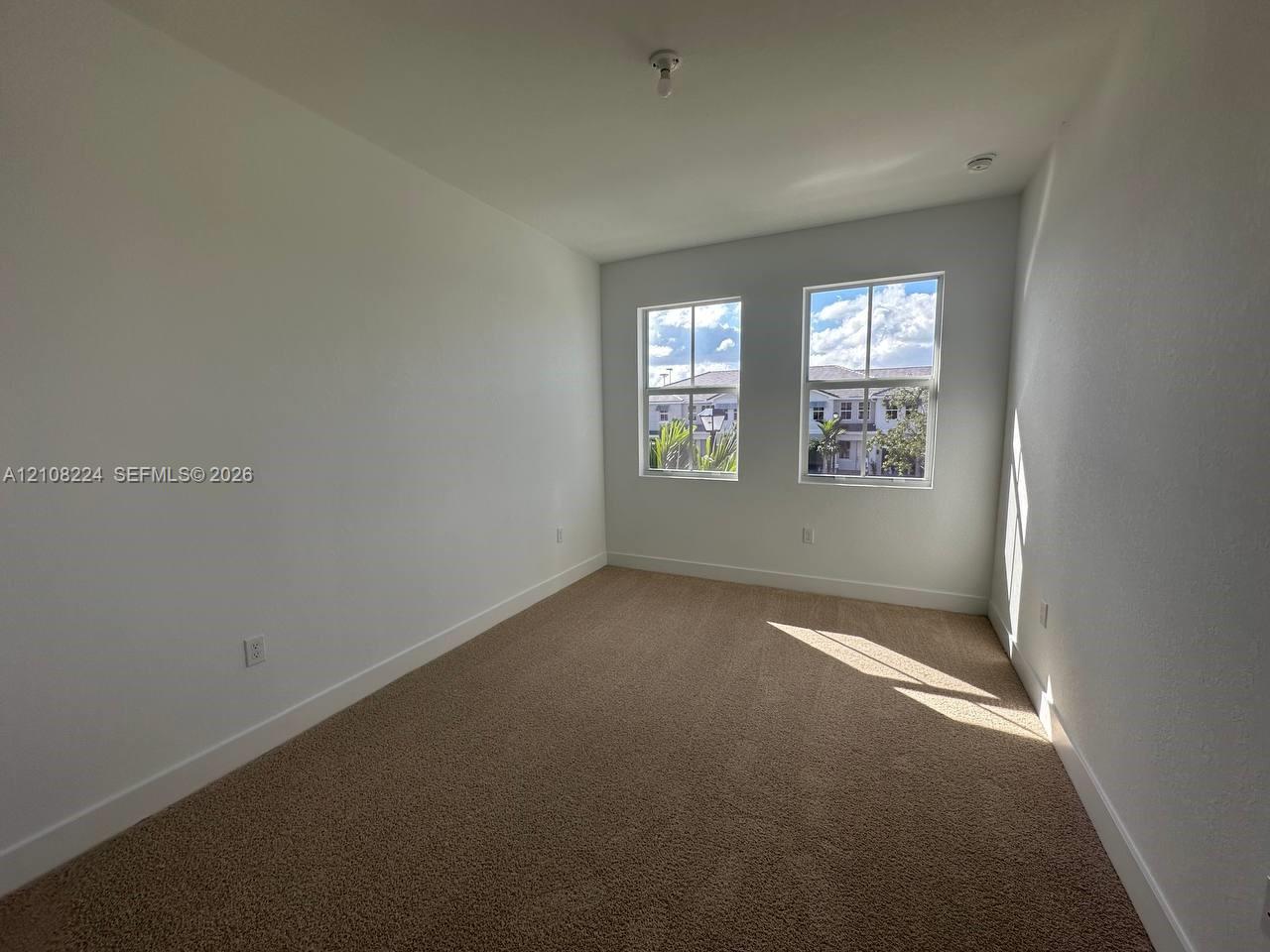 Neutral-toned carpeting, dual-pane windows with muntins, and textured walls