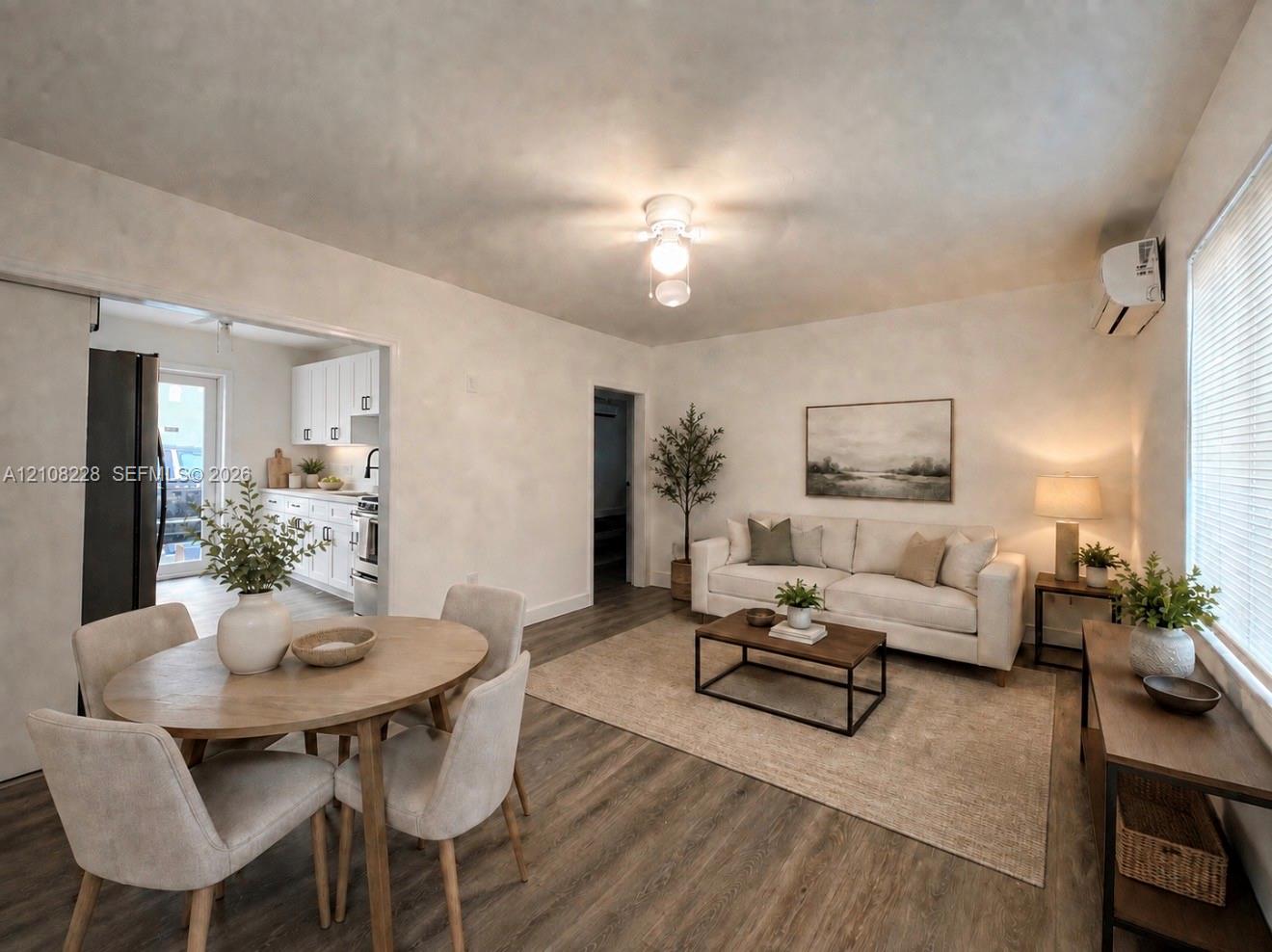 Neutral interior featuring wood-finish flooring, recessed ceiling lighting, and a wall-mounted climate control unit