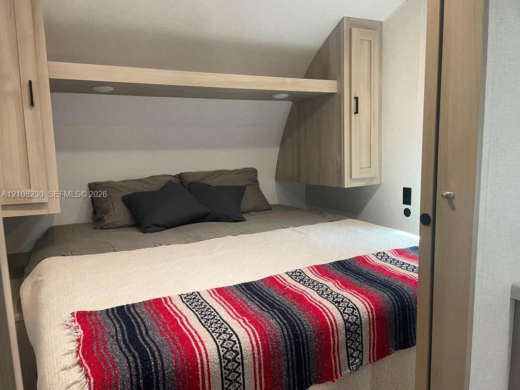 Built-in cabinetry with light wood finish, integrated overhead shelving, and recessed lighting