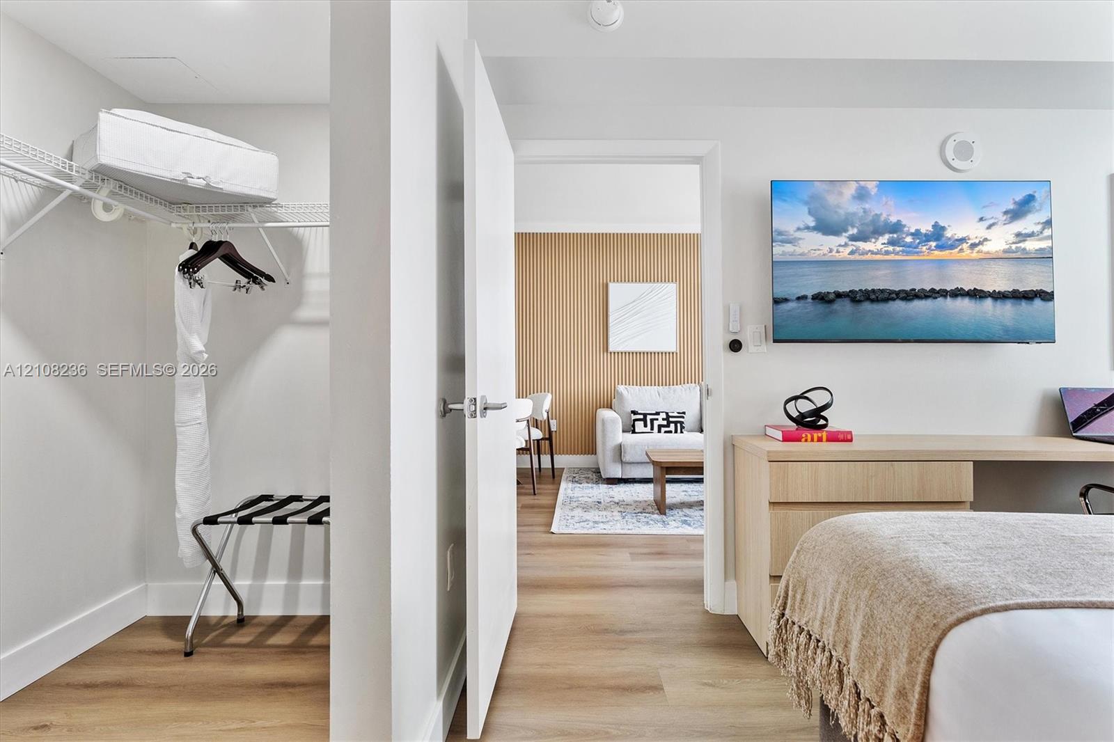 Interior space featuring wood-finish flooring, a built-in closet with wire shelving, and a custom built-in desk with integrated cabinetry