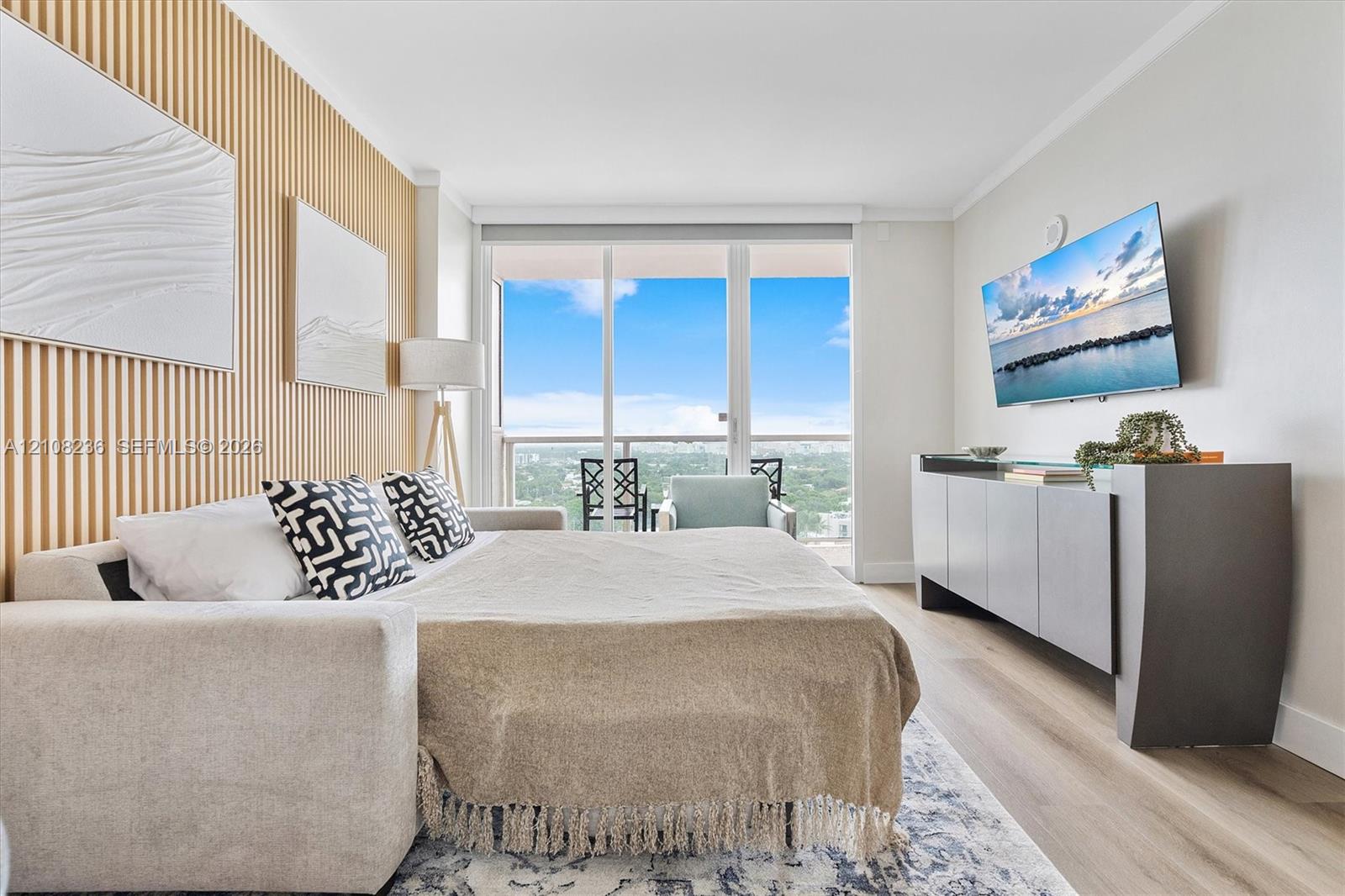 Vertical wood-slat accent wall, full-height sliding glass doors, and light-toned wood-finish flooring