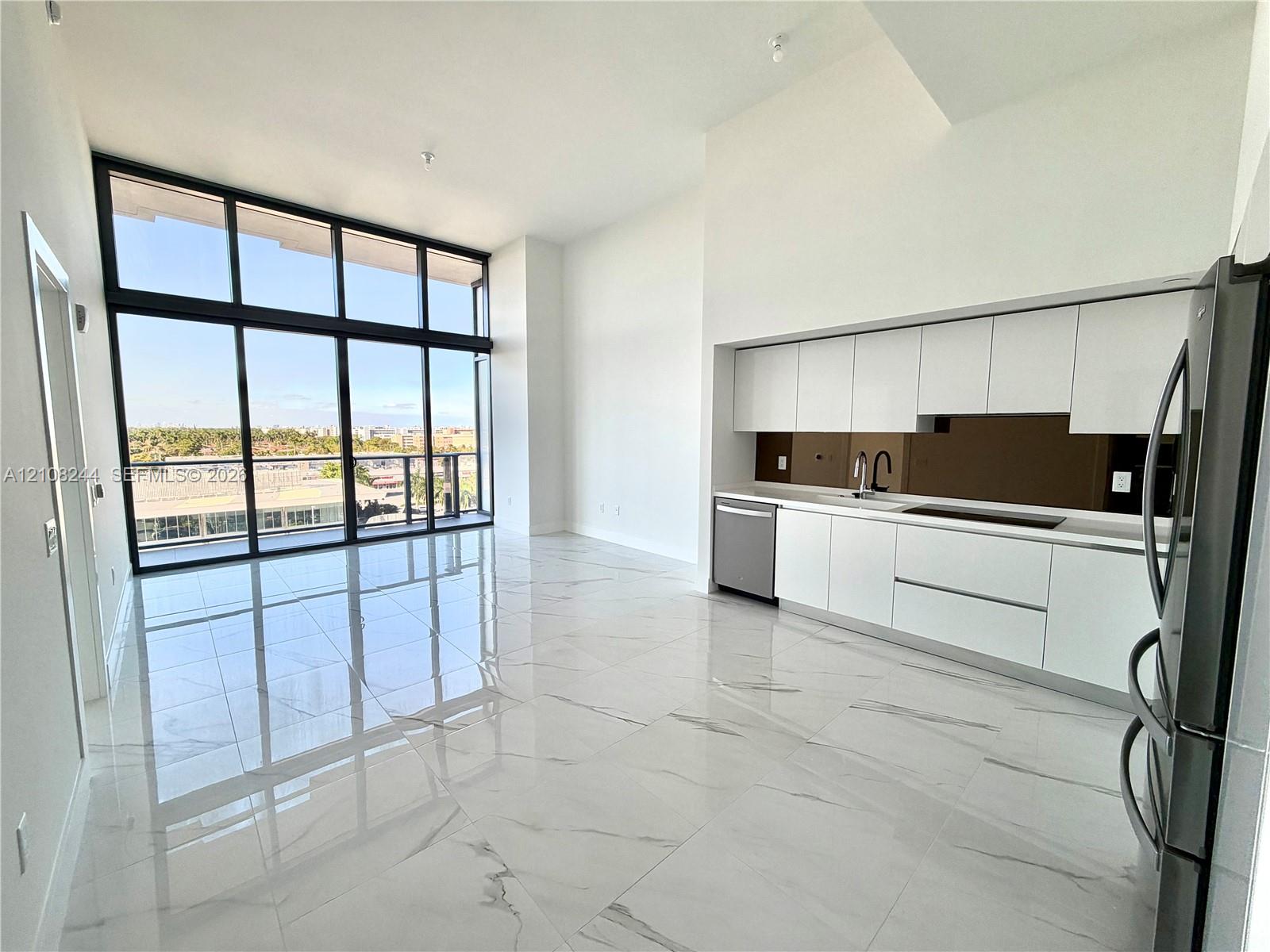 Floor-to-ceiling windows, high-gloss tile flooring, flat-panel cabinetry, and a built-in floating media console