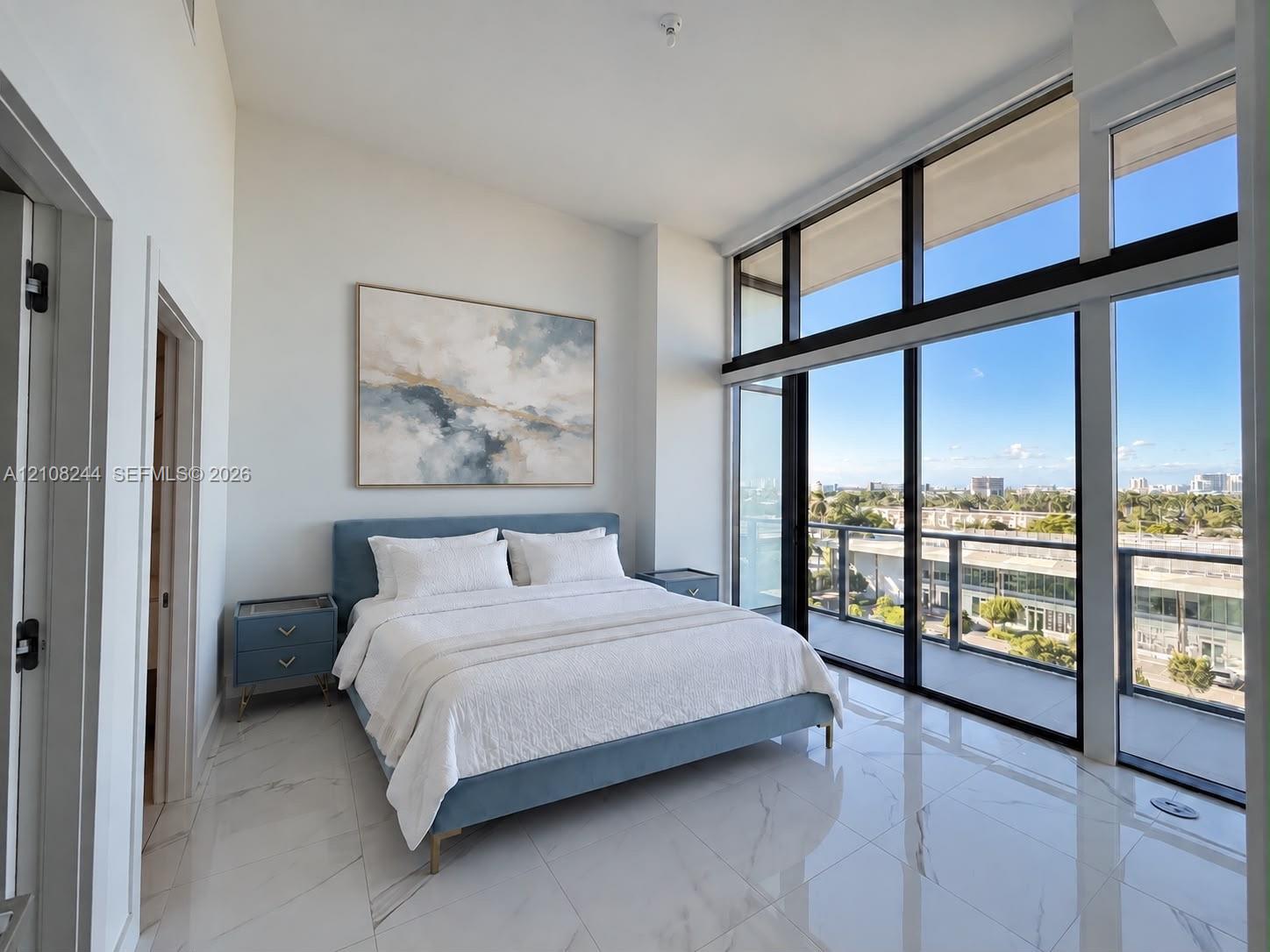 High ceilings featuring floor-to-ceiling windows with balcony access and light-toned, vein-patterned tile flooring High ceilings featuring floor-to-ceiling windows with balcony access and light-toned, vein-patterned tile flooring