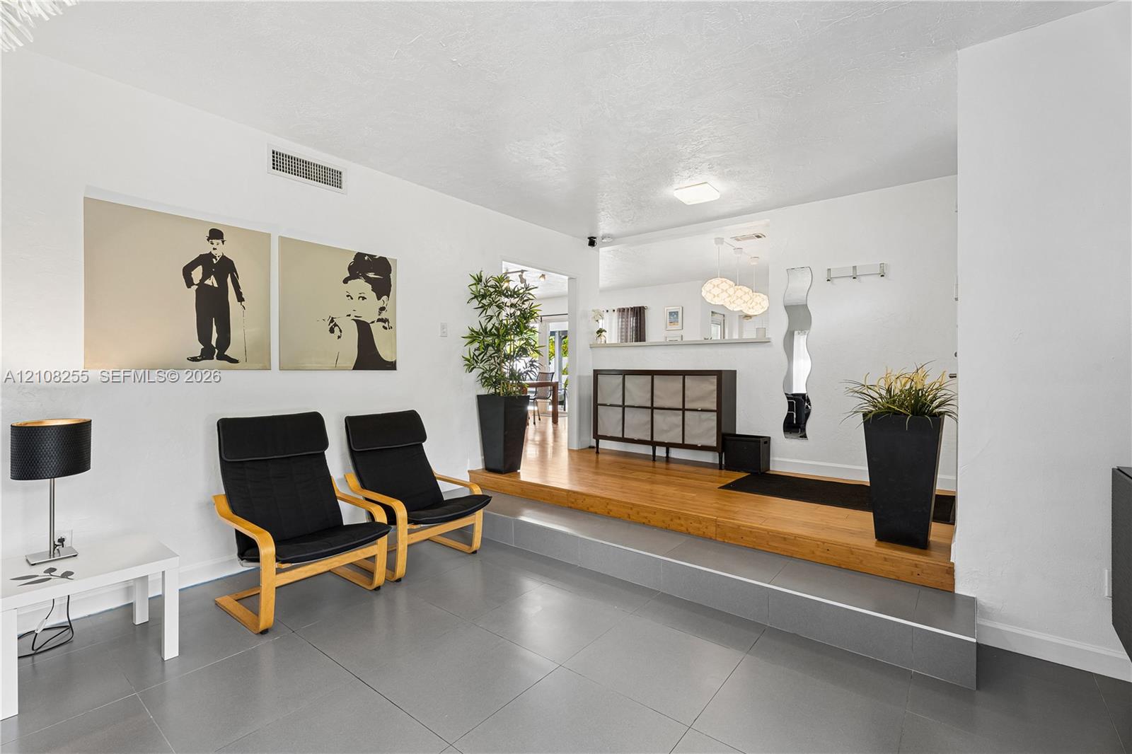 Multi-level flooring featuring large-format grey tile and raised wood-finish platform