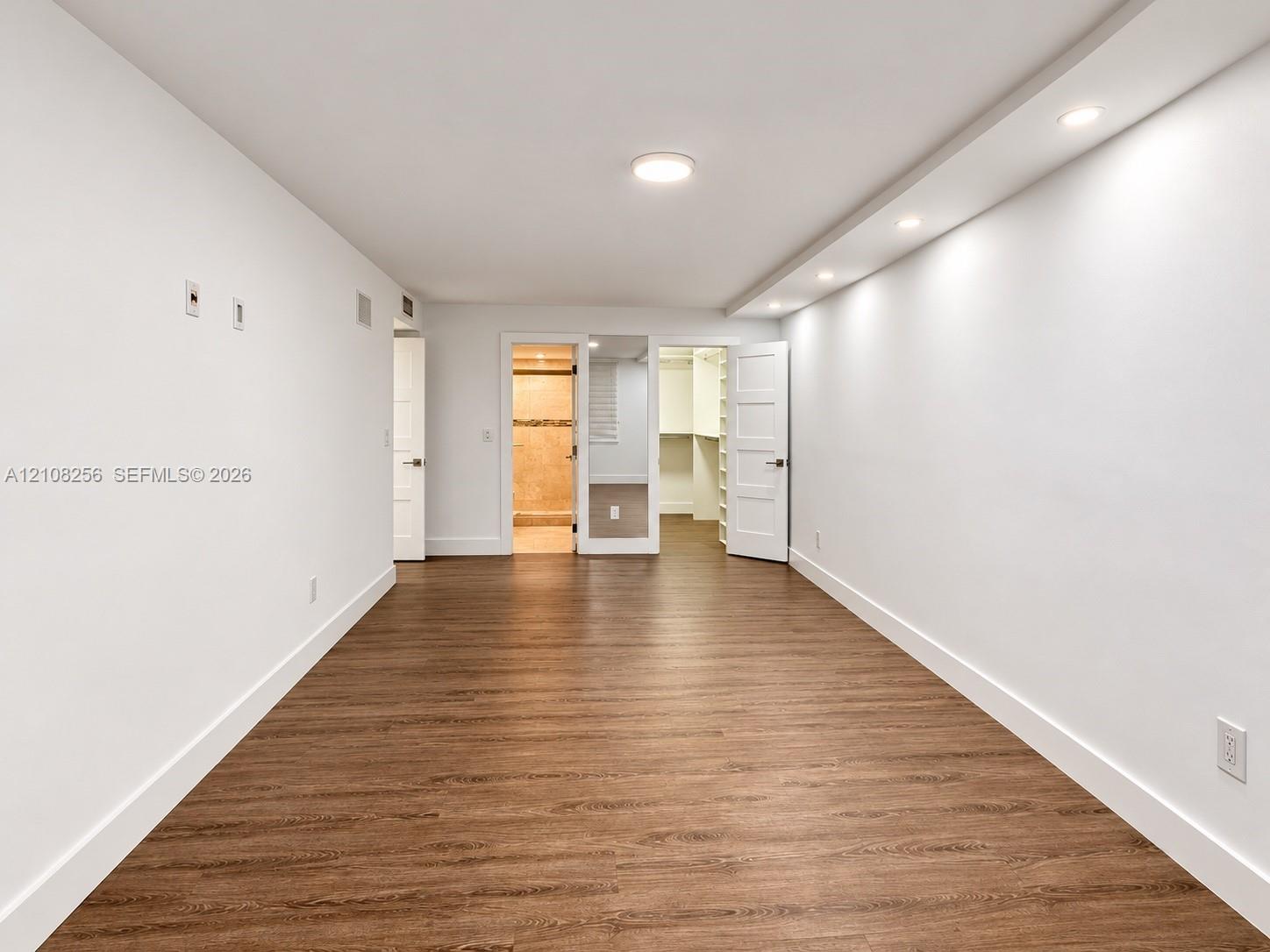 Wood-finish flooring, recessed soffit lighting, and built-in closet shelving