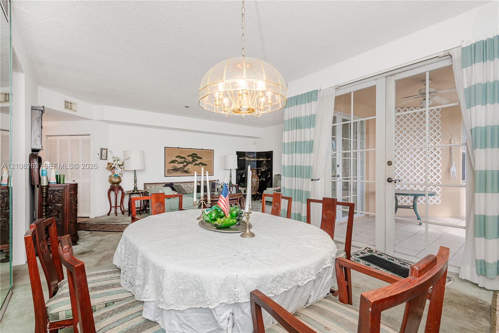 Dining space featuring a multi-tiered glass dome chandelier and glass-paned sliding doors opening to an exterior patio