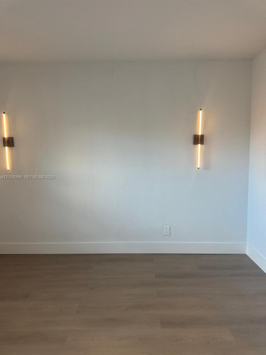 Wood-finish flooring paired with two contemporary linear wall-mounted light fixtures