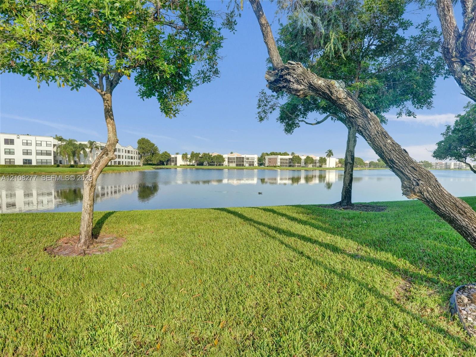 Waterfront lot featuring a manicured lawn, mature trees, and direct water access