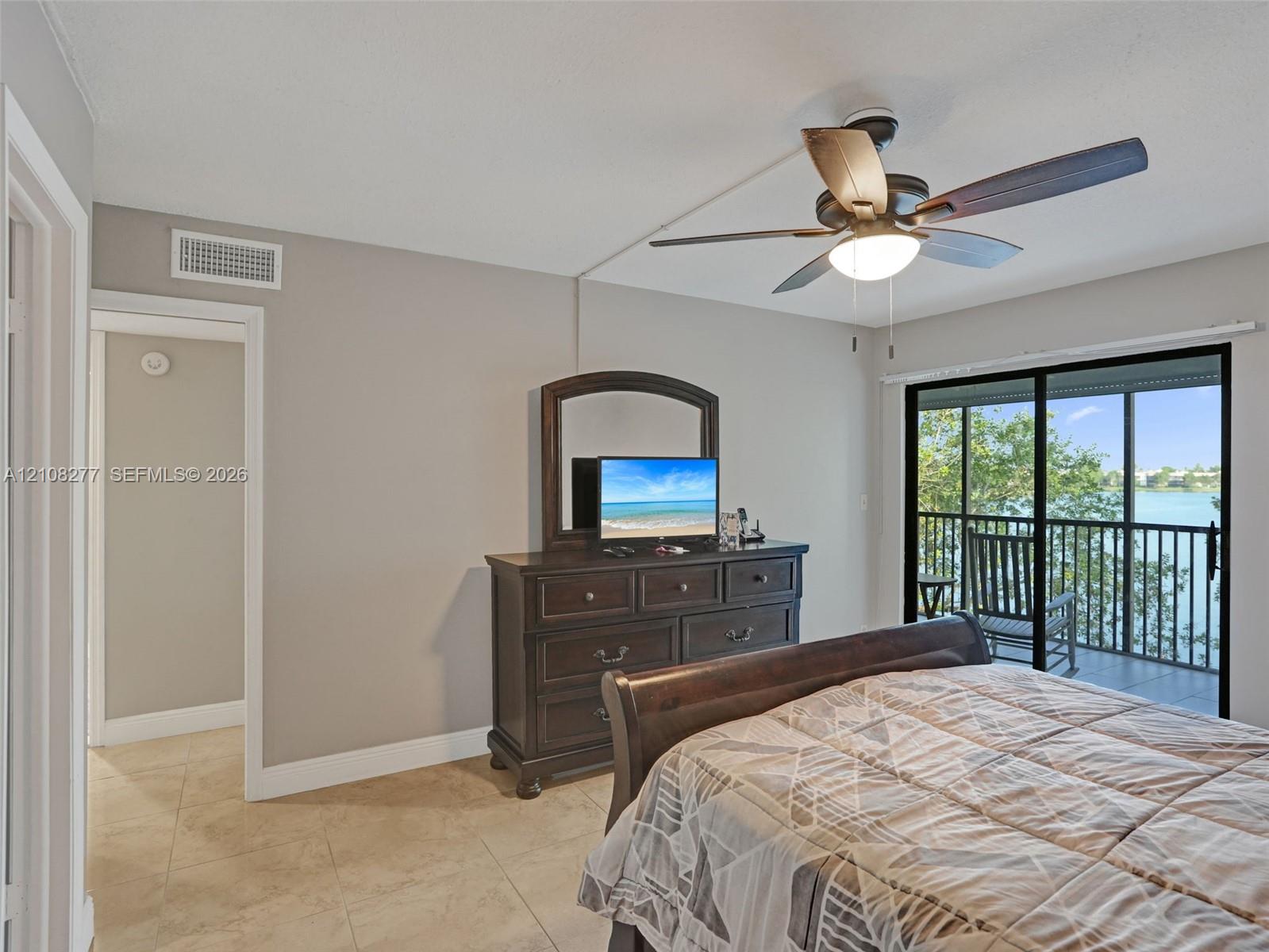 Ceramic tile flooring, ceiling fan with integrated lighting, and glass sliding doors opening to a screened balcony