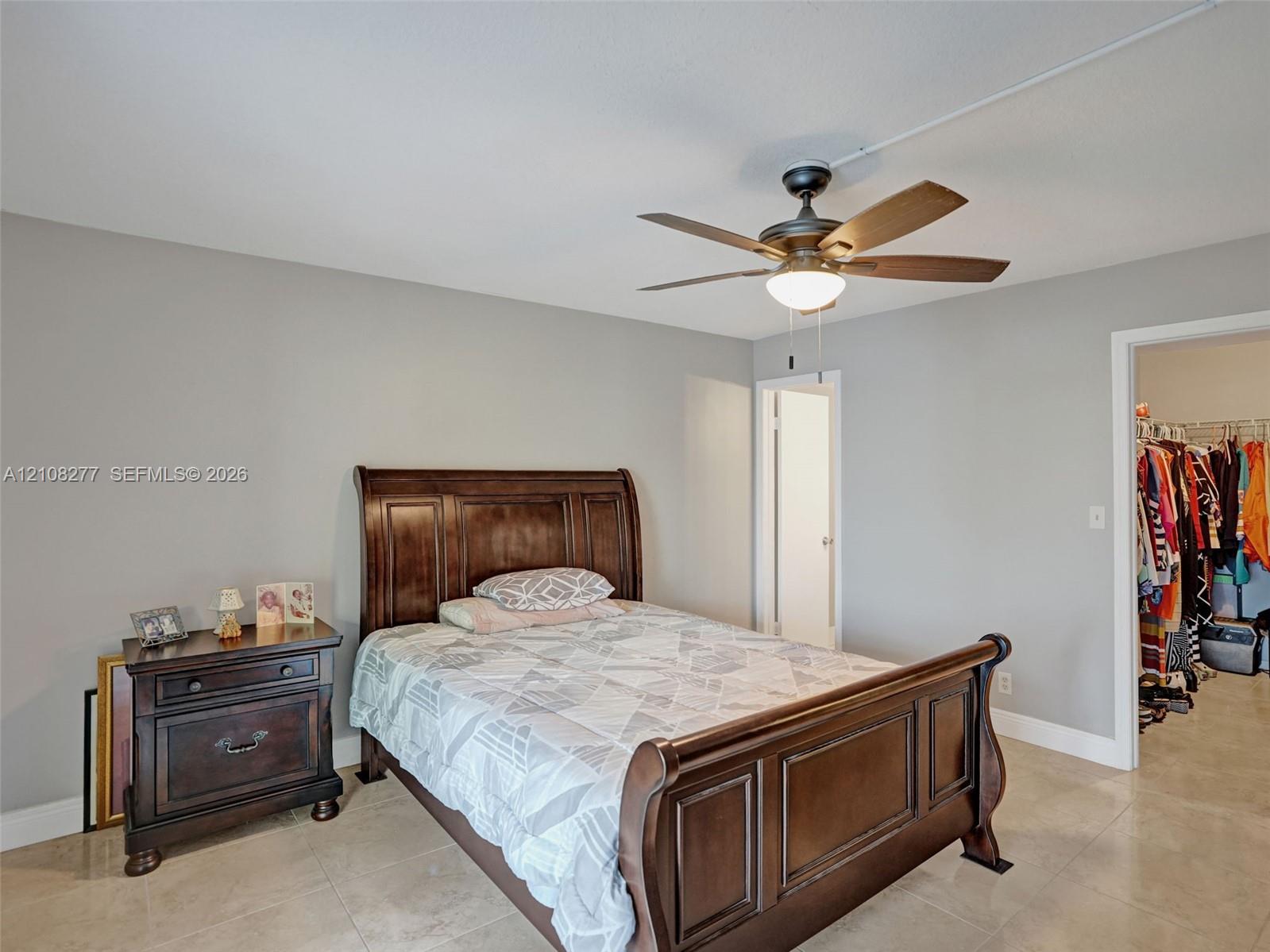 Neutral interior walls, tile flooring, and a ceiling-mounted fan with integrated lighting