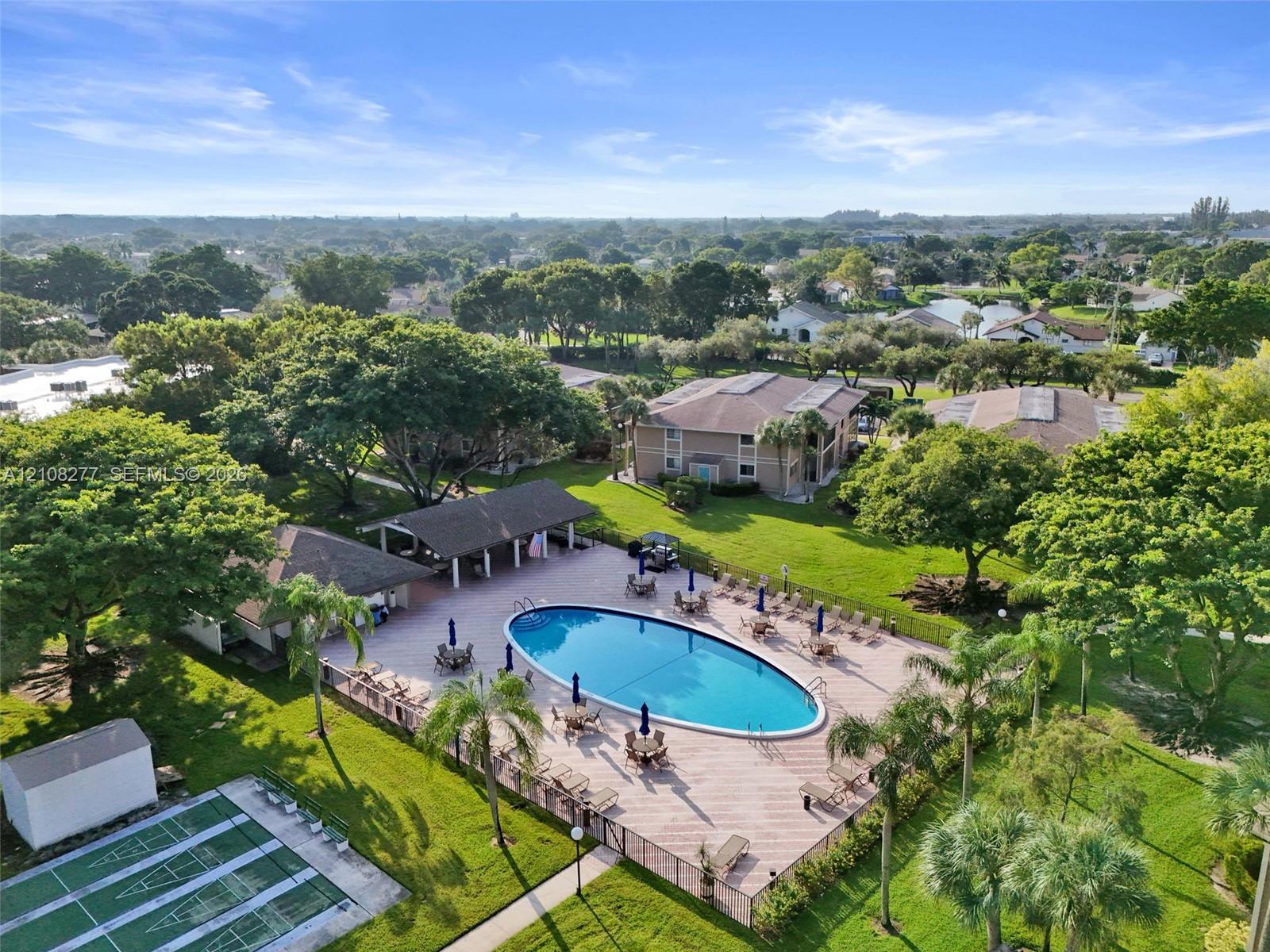 Community amenities featuring a fenced pool, covered pavilion, and hard-surface court situated within landscaped grounds