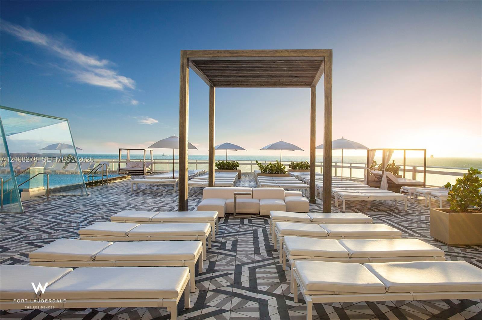 Rooftop terrace featuring a swimming pool, glass-panel perimeter fencing, custom geometric-patterned hardscaping, and a large wood-finish pergola
