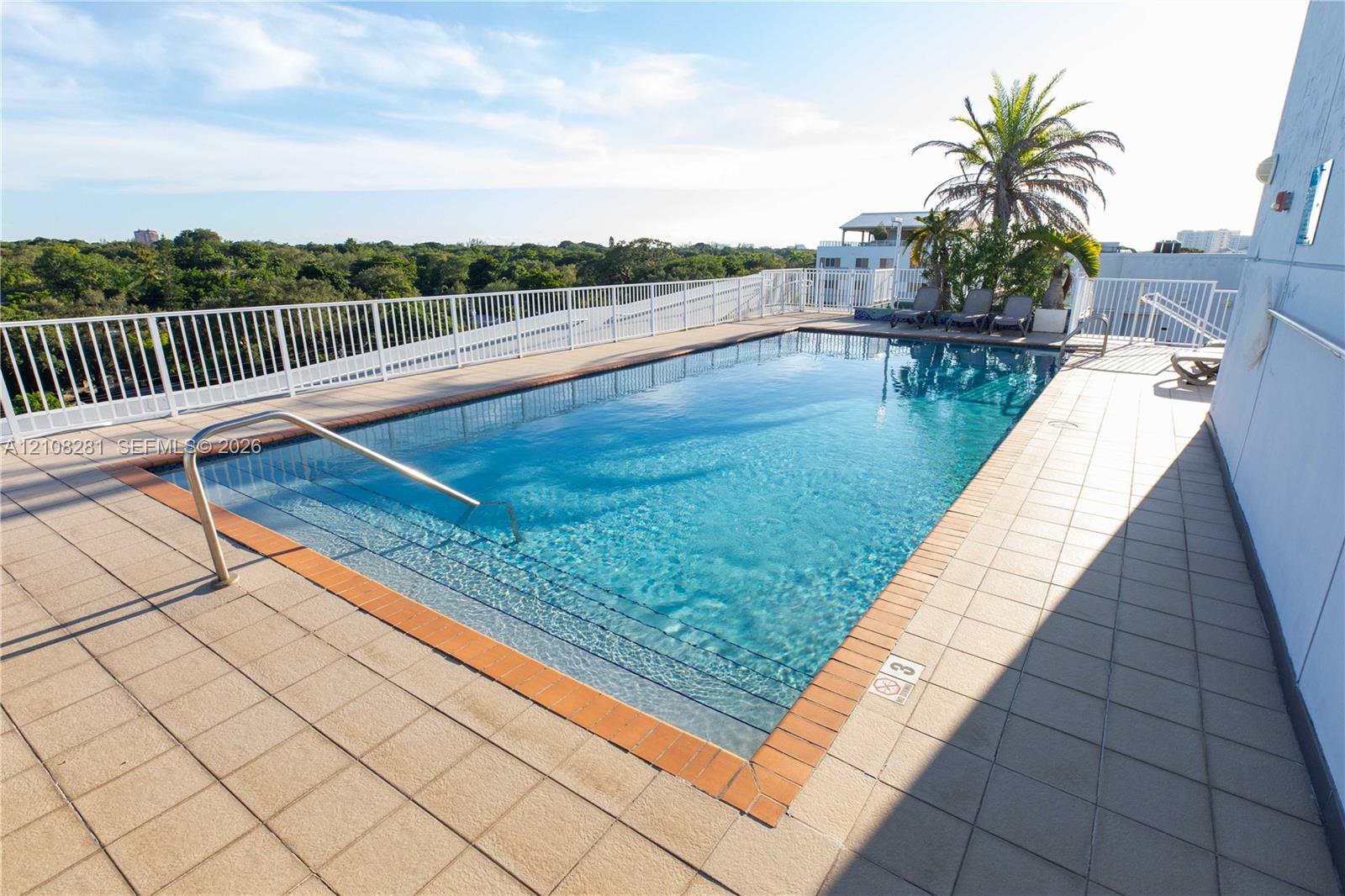 Rooftop pool featuring tile decking, a metal perimeter railing, and integrated pool entry steps with a metal handrail