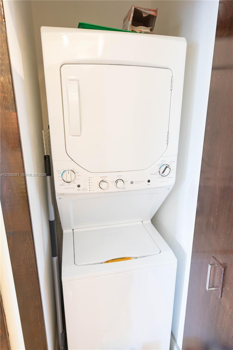 White stacked laundry center with top-load washer and front-load dryer configuration