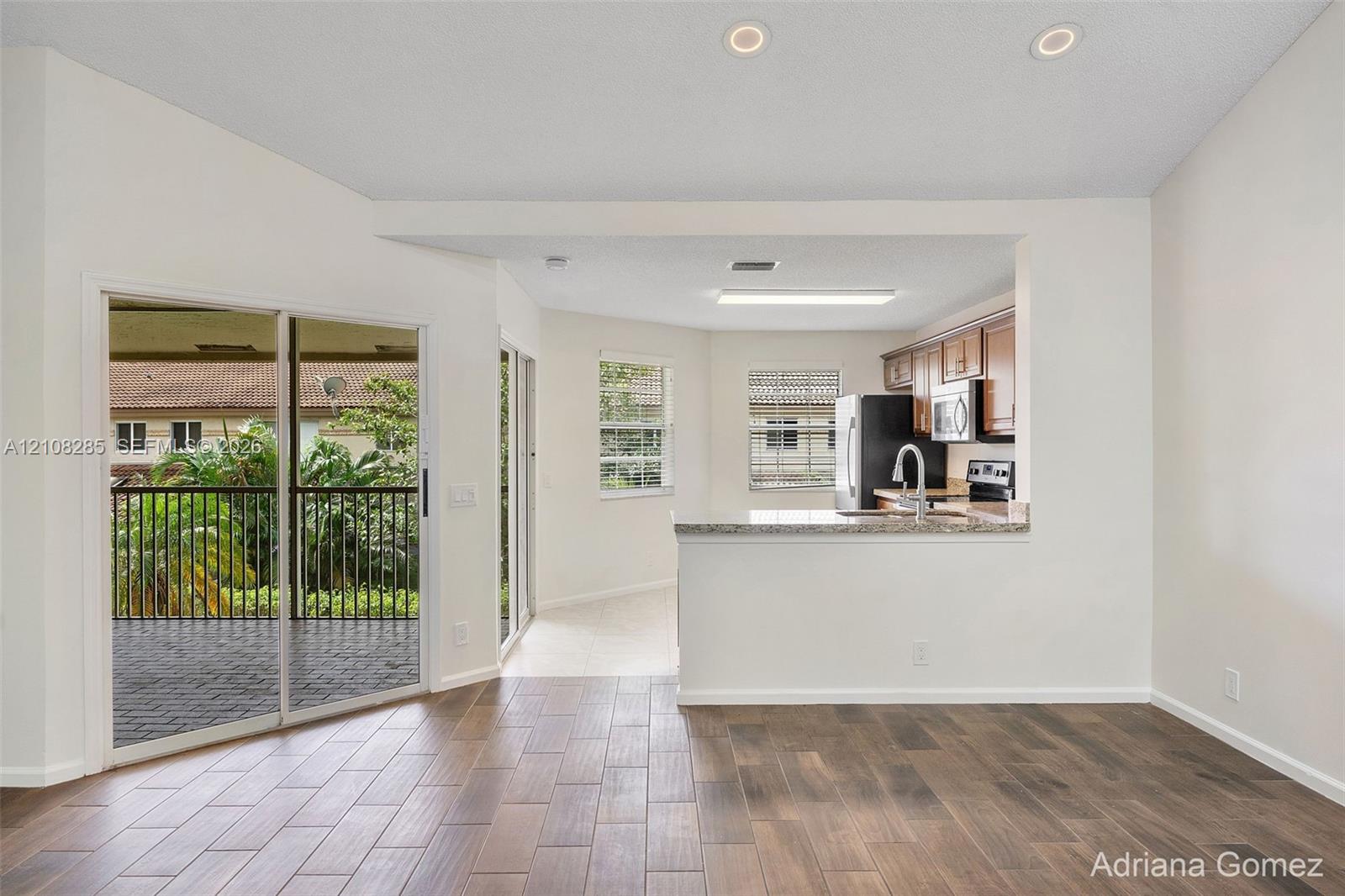 Kitchen featuring a stone-surface breakfast bar, wood-finish flooring, sliding glass doors, and recessed lighting