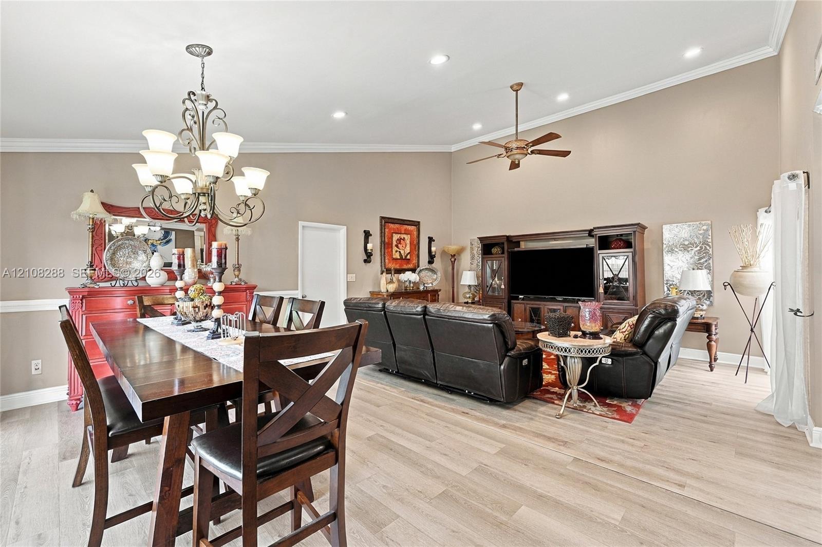 Vaulted ceilings with recessed lighting, wood-finish flooring, crown molding, and an ornate wrought-iron chandelier Vaulted ceilings with recessed lighting, wood-finish flooring, crown molding, and an ornate wrought-iron chandelier
