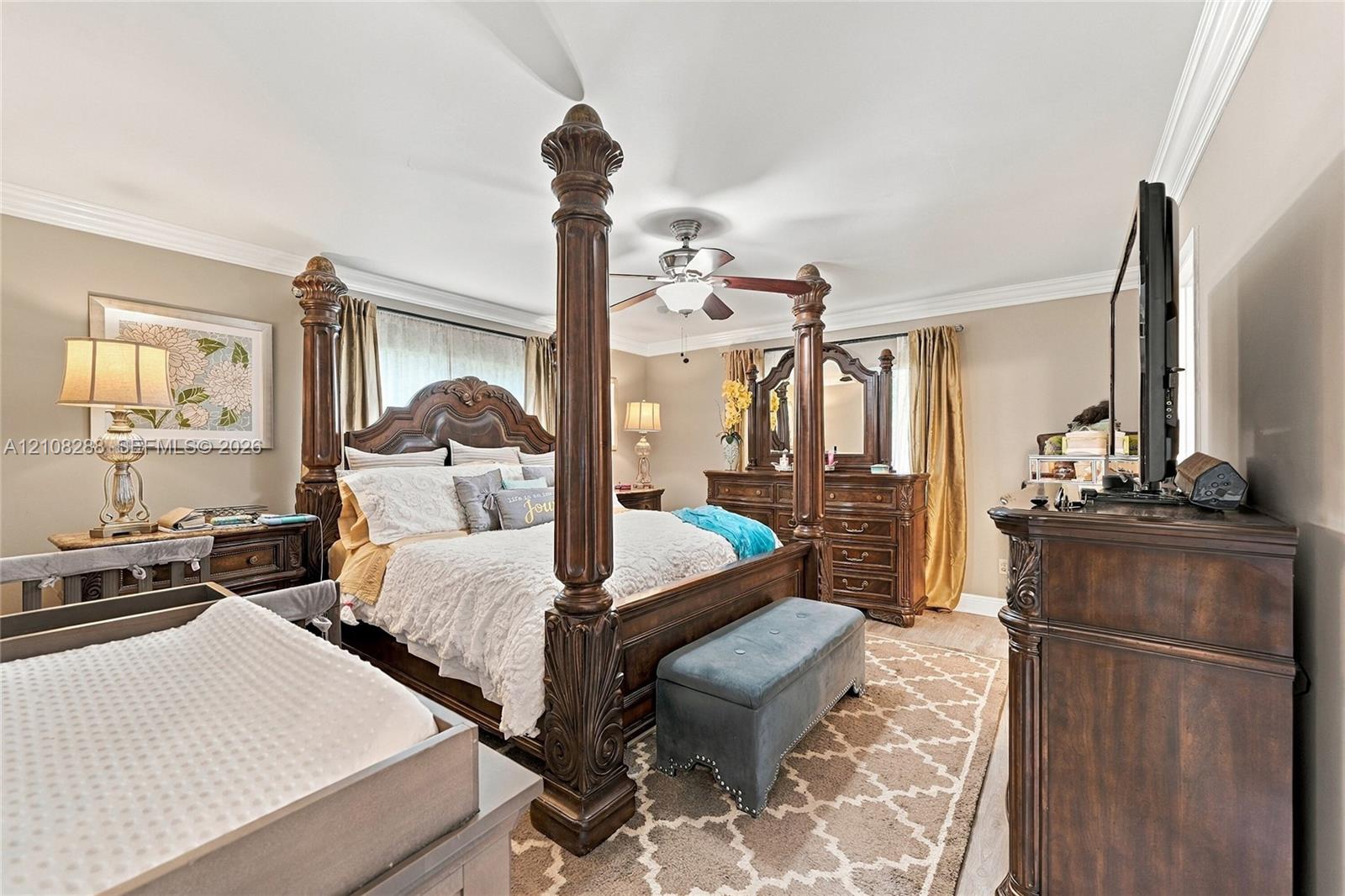 Bedroom featuring crown molding, neutral wall tones, and a ceiling fan with integrated lighting