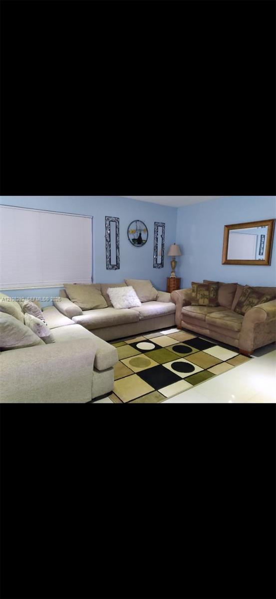 Room featuring light blue wall paint and large-format tile flooring