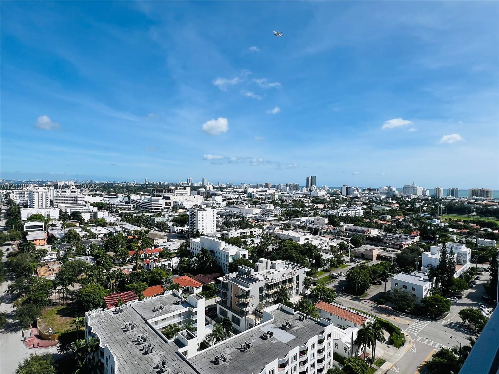 Elevated aerial perspective featuring a panoramic urban landscape with coastal horizon Elevated aerial perspective featuring a panoramic urban landscape with coastal horizon