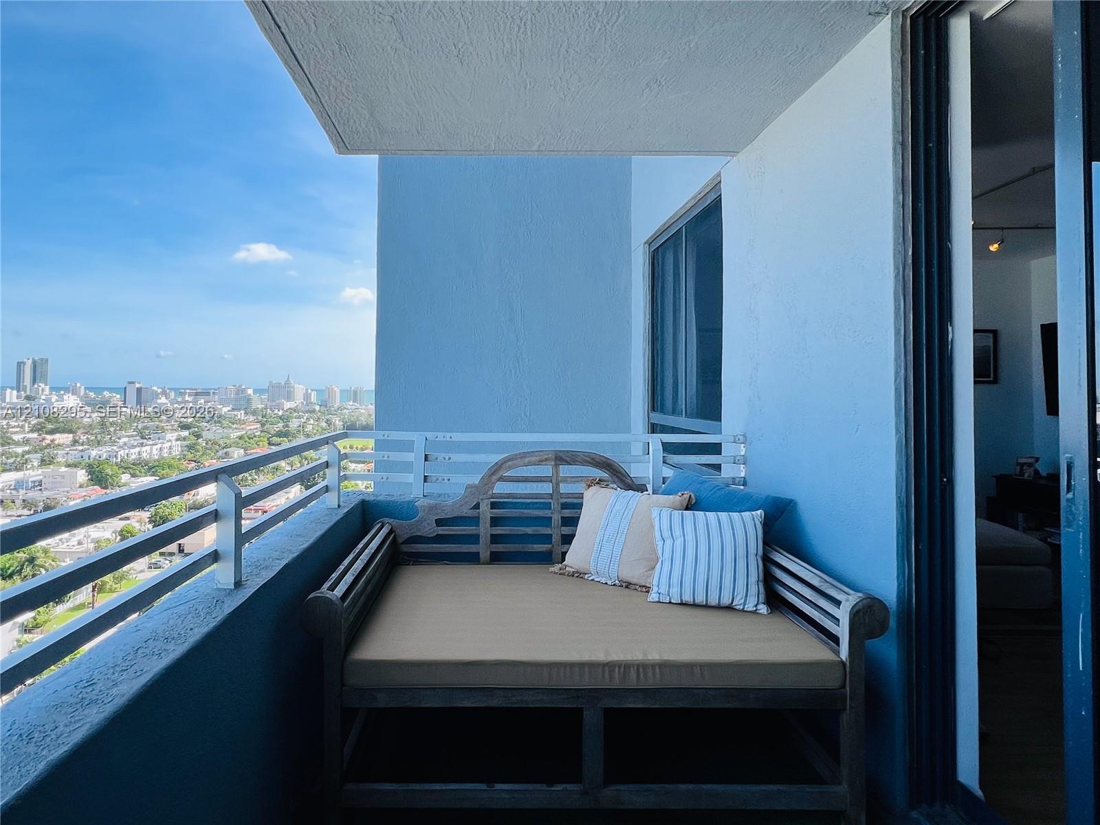 Private balcony with a metal horizontal railing, featuring a concrete ceiling and expansive cityscape scenery Private balcony with a metal horizontal railing, featuring a concrete ceiling and expansive cityscape scenery