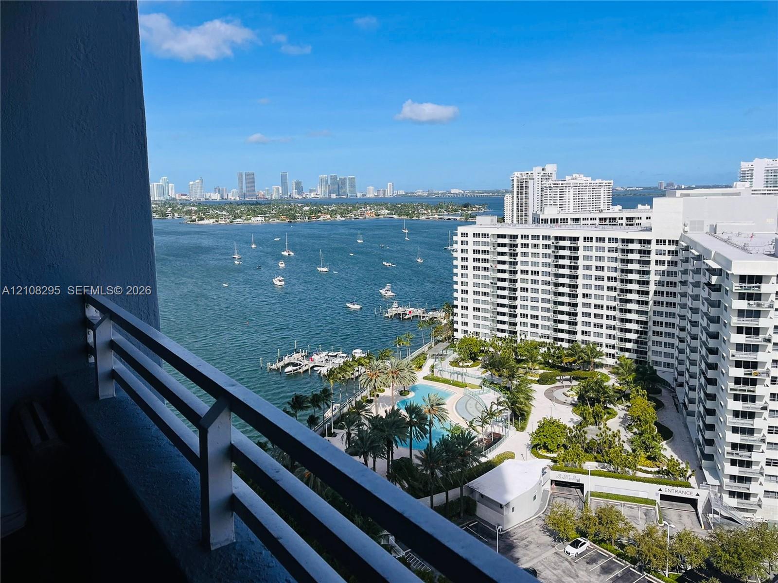 Private balcony featuring a metal railing with a wide-angle perspective of the waterfront, marina, and city skyline Private balcony featuring a metal railing with a wide-angle perspective of the waterfront, marina, and city skyline
