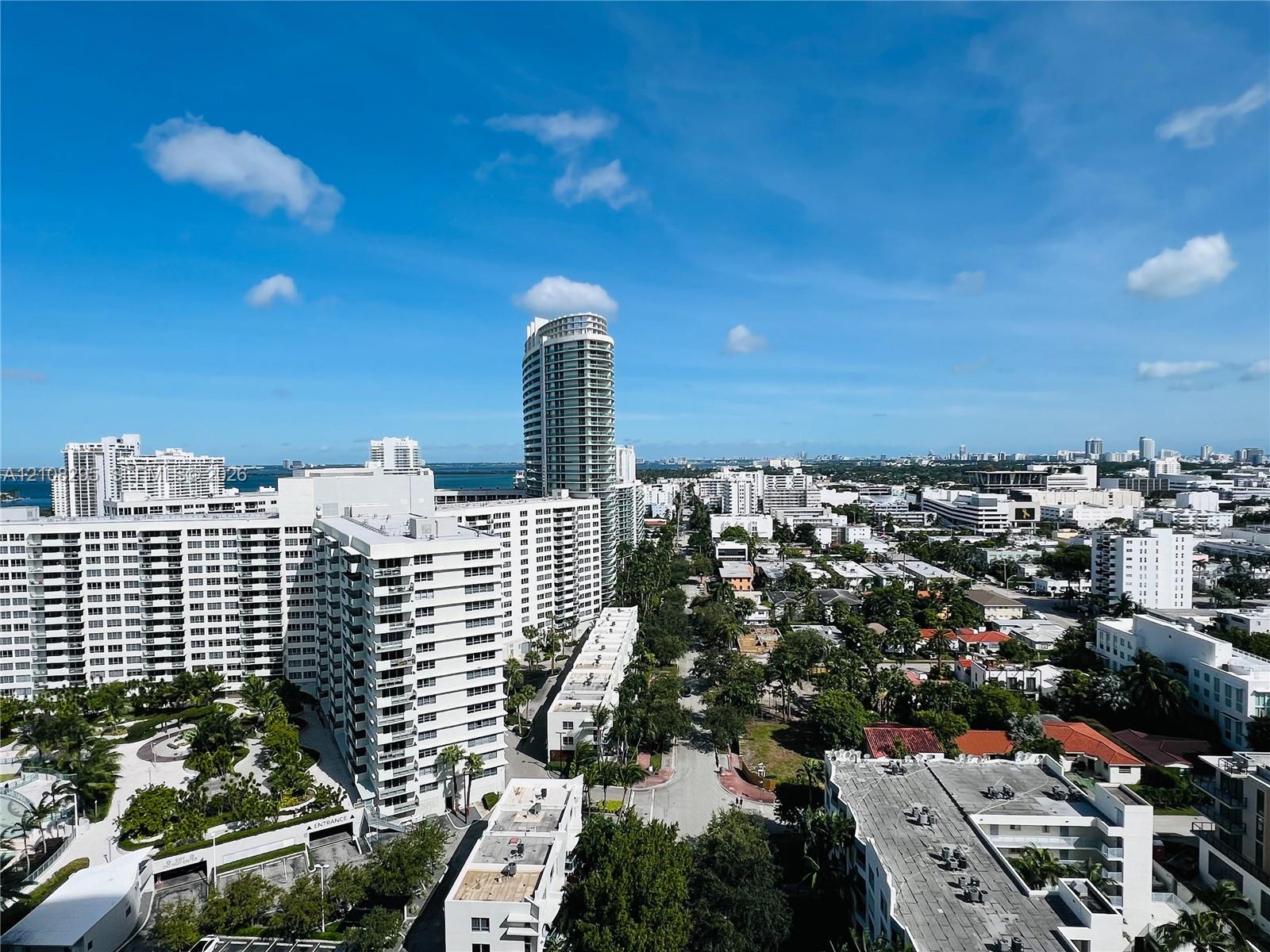 High-rise balcony perspective featuring panoramic cityscape and water horizons High-rise balcony perspective featuring panoramic cityscape and water horizons