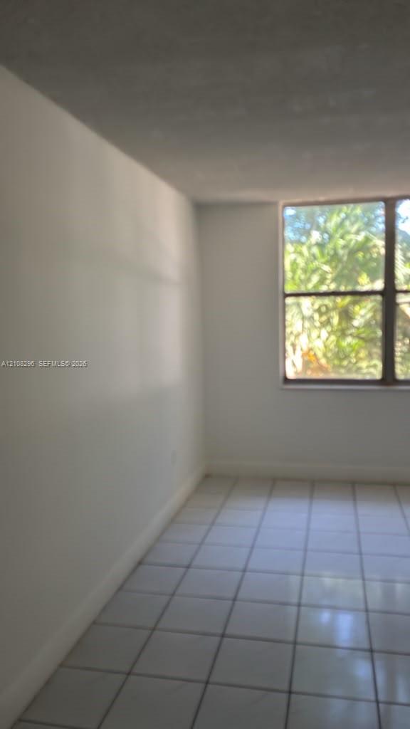 Interior space featuring large-format tile flooring and a multi-pane window