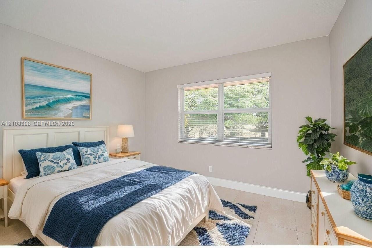 Neutral-toned interior walls featuring a large multi-pane window with horizontal blinds and light-colored tile flooring