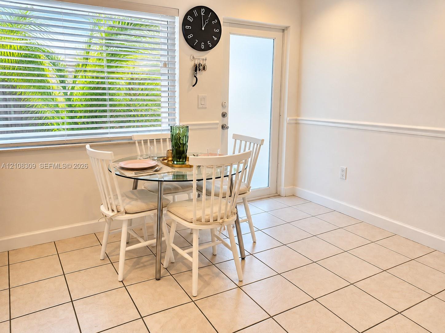 Ceramic tile flooring, white chair rail molding, large horizontal blind window, and glass-paneled exterior door Ceramic tile flooring, white chair rail molding, large horizontal blind window, and glass-paneled exterior door