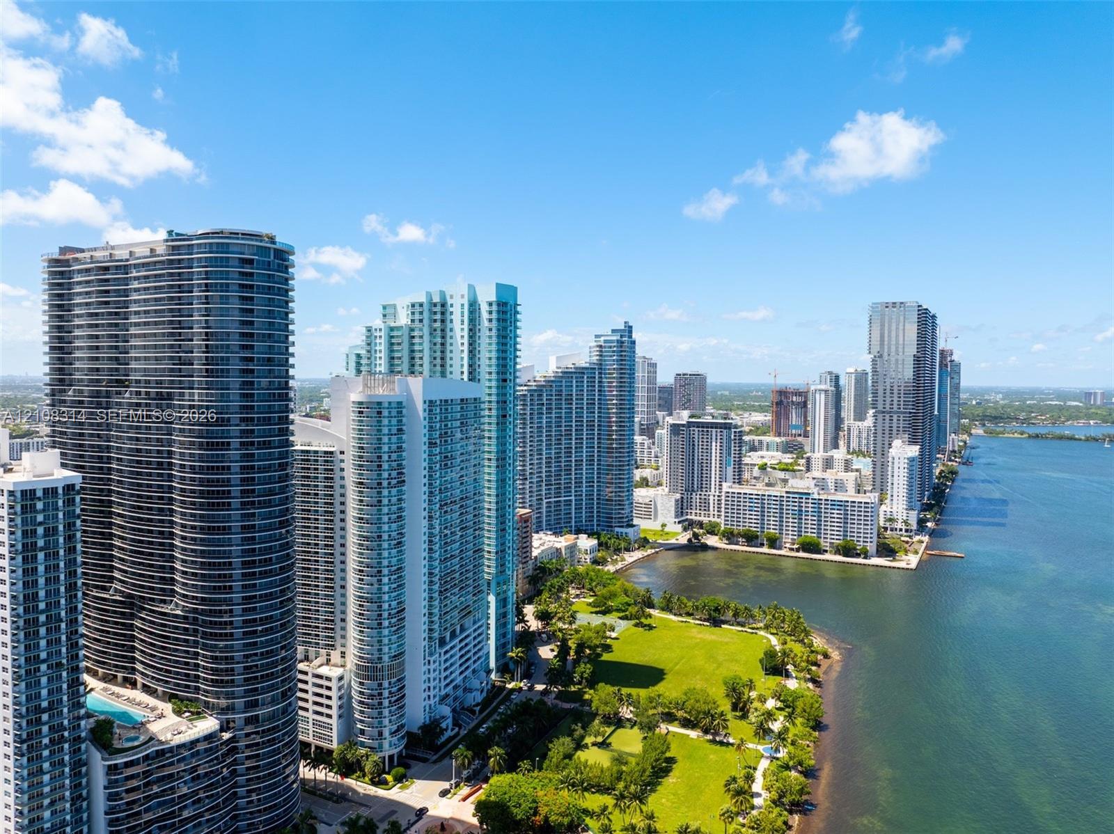 High-rise coastal cityscape featuring waterfront access, expansive green space, and architectural tower structures
