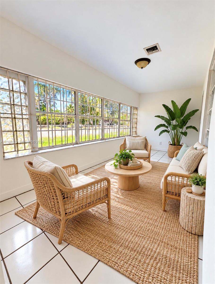 Enclosed space featuring large, grid-patterned casement windows, white ceramic tile flooring, and a flush-mount ceiling fixture Enclosed space featuring large, grid-patterned casement windows, white ceramic tile flooring, and a flush-mount ceiling fixture