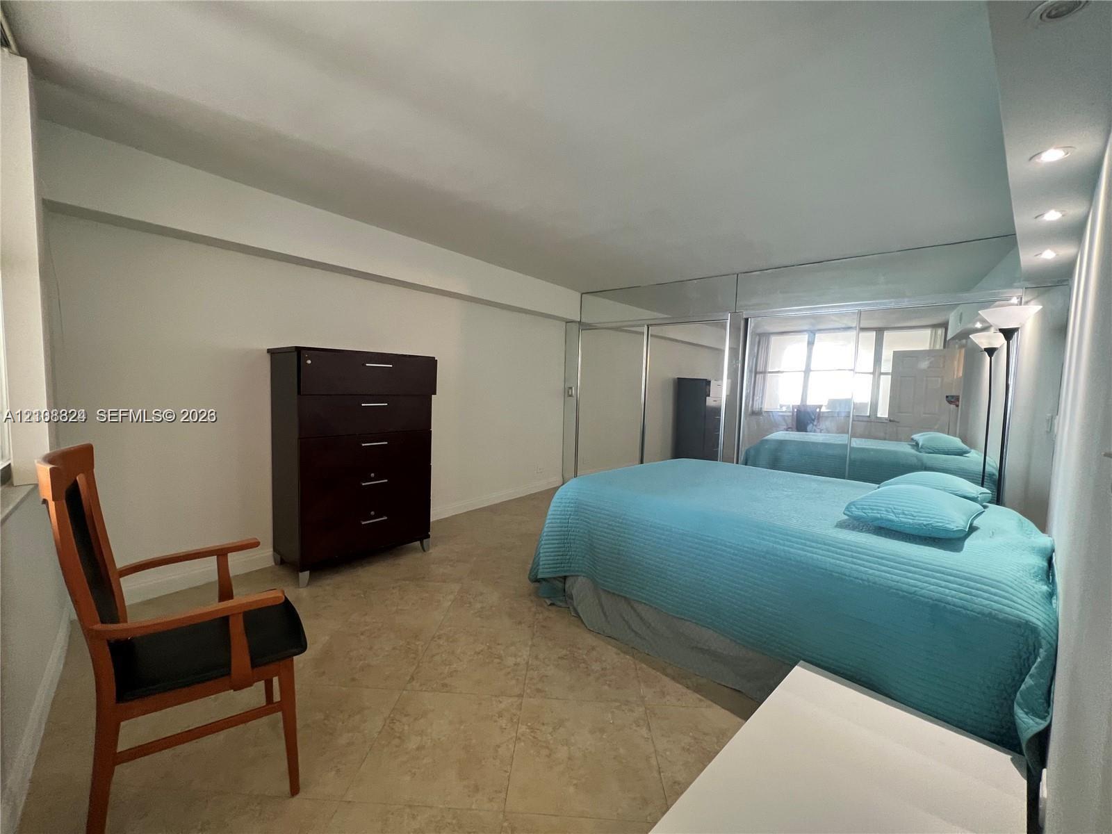Tile flooring, floor-to-ceiling mirrored closet doors, and recessed ceiling lighting