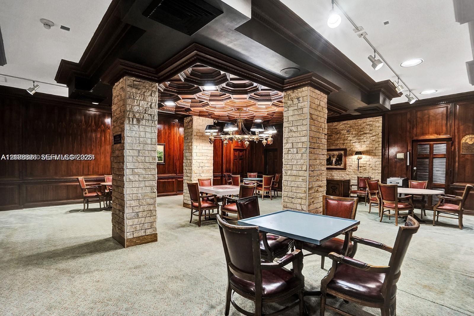 Custom coffered wood ceiling, stone-clad structural columns, rich wood-paneling, and integrated track lighting