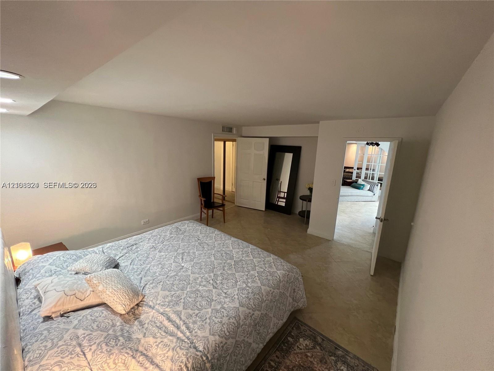 Neutral interior space featuring recessed ceiling lighting, light-toned tile flooring, and multiple doorways