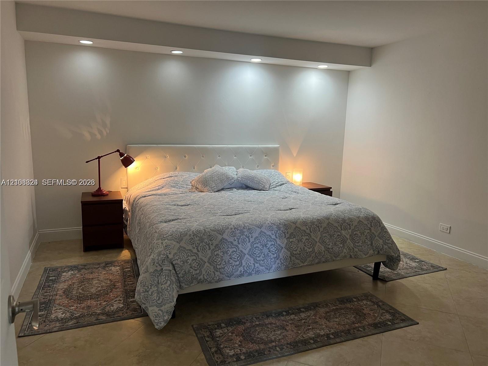 Neutral-toned interior featuring large-format tile flooring and an architectural soffit with recessed downlighting