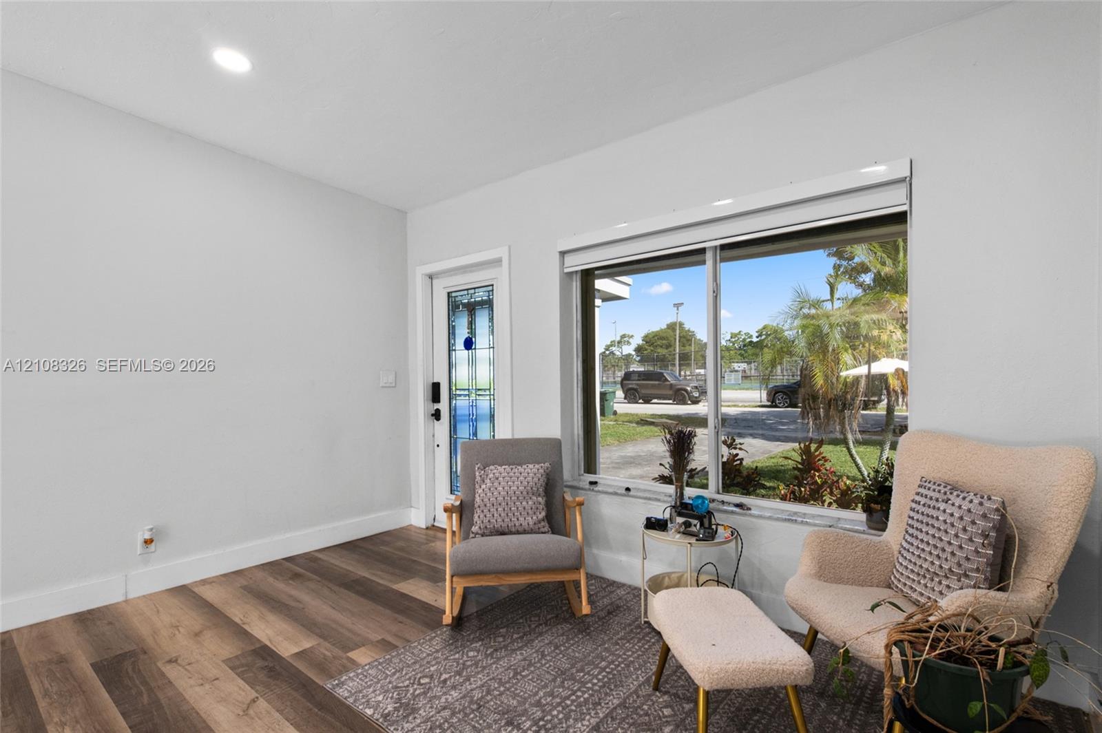 Wood-finish flooring, large picture window, and exterior door with decorative glass inlay and recessed lighting Wood-finish flooring, large picture window, and exterior door with decorative glass inlay and recessed lighting