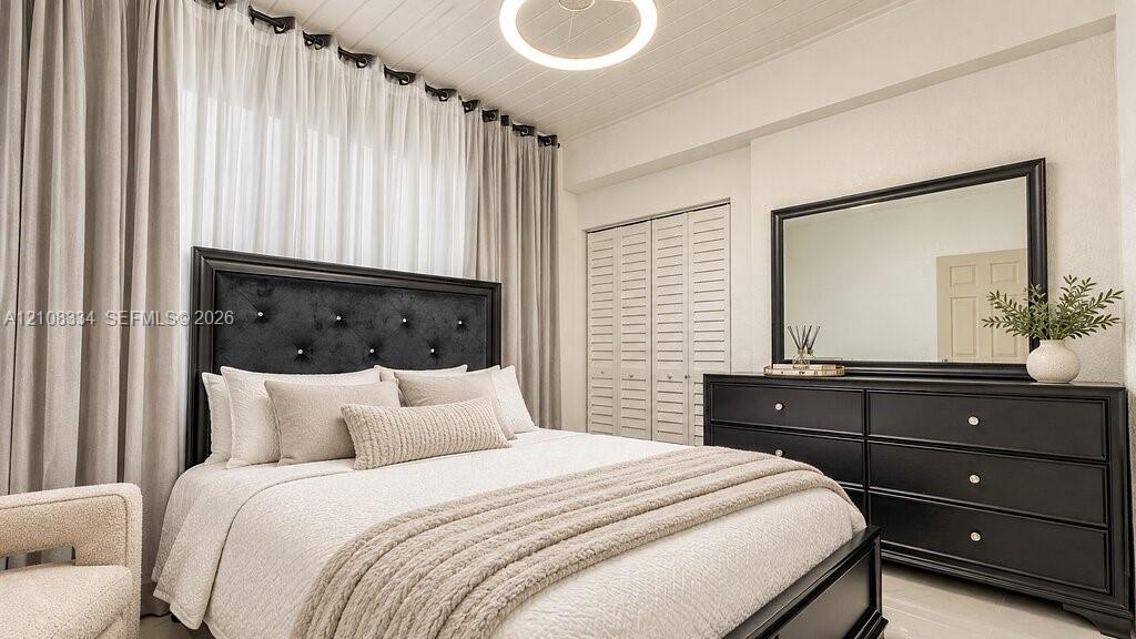 Beadboard ceiling featuring a circular flush-mount light fixture and floor-to-ceiling drapery window treatment with louvered-style bi-fold closet doors