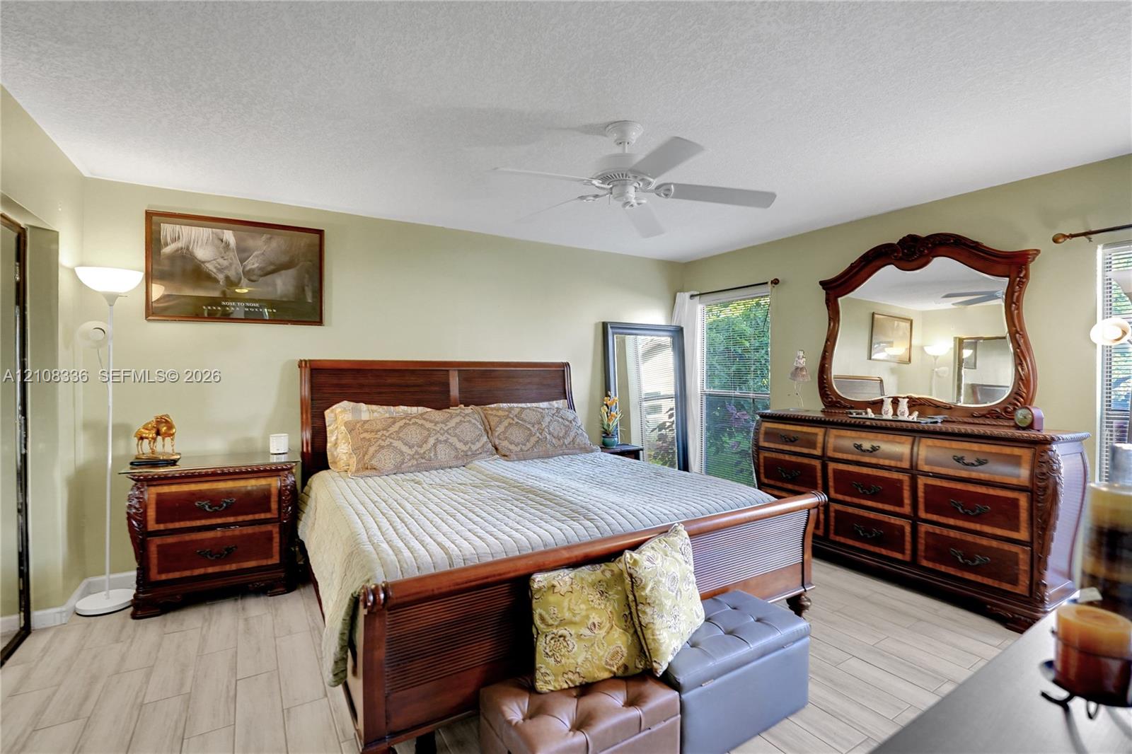 Wood-finish tile flooring, ceiling fan, and windows with natural light