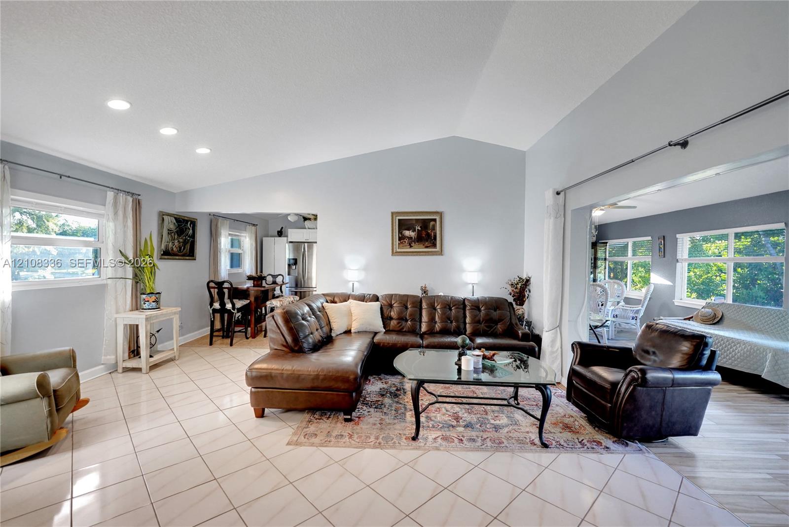 Living area featuring vaulted ceilings, recessed lighting, and ceramic tile flooring