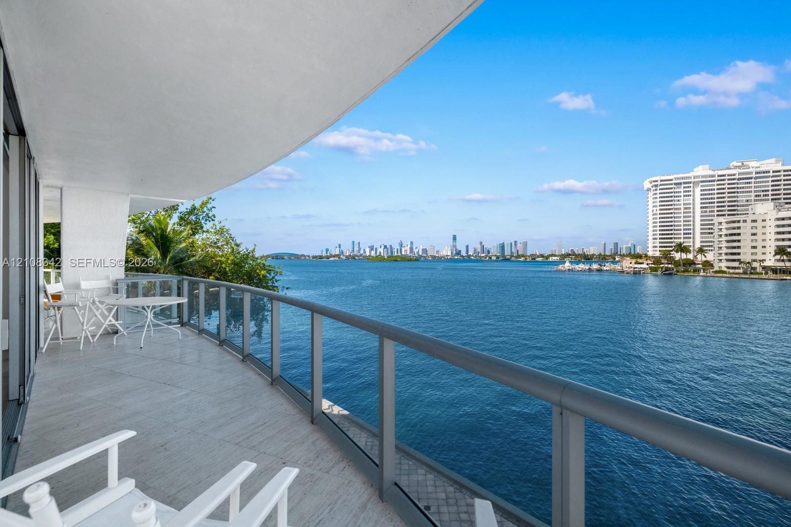 Curved balcony featuring light-toned tile flooring and a glass-panel railing with metal frame