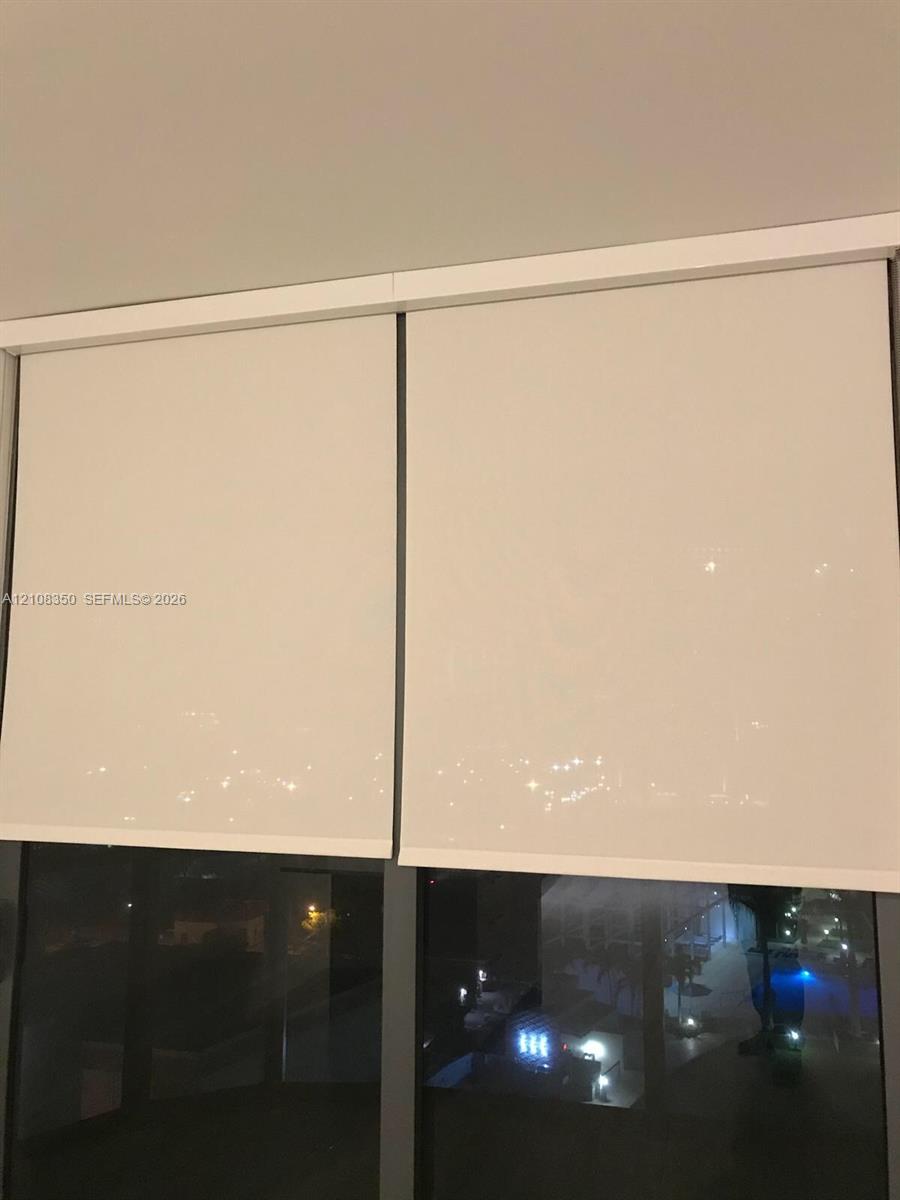 Floor-to-ceiling windows featuring dual-pane glazing, dark-finish metal frames, and integrated retractable roller shades