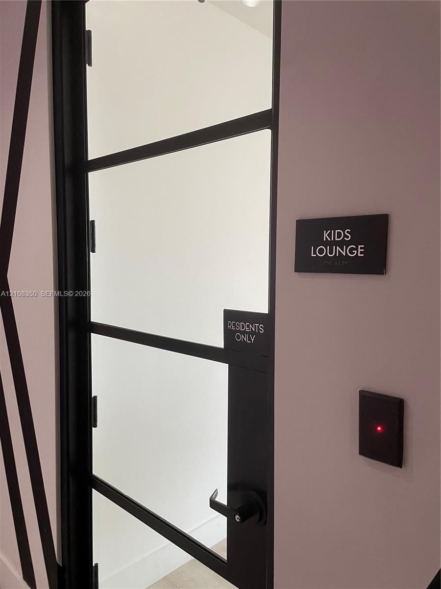 Black-framed glass door with metal lever handle and electronic access control