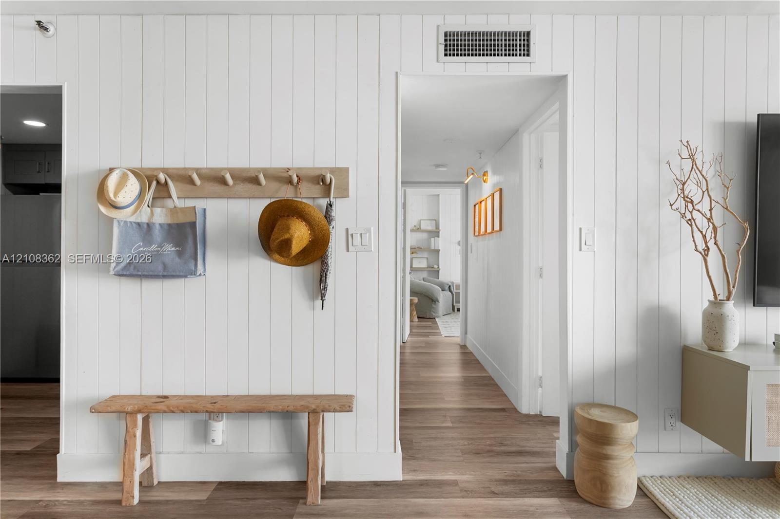 Vertical shiplap wall paneling paired with wood-finish flooring throughout