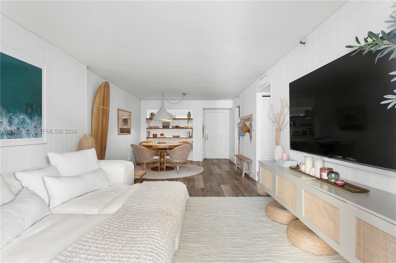 Vertical paneled walls, wood-finish flooring, and recessed built-in shelving with integrated lighting