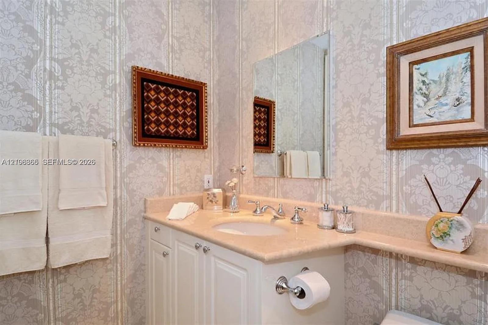 Custom vanity with integrated countertop and backsplash, undermount sink, dual-handle chrome faucet, and wall-mounted mirror